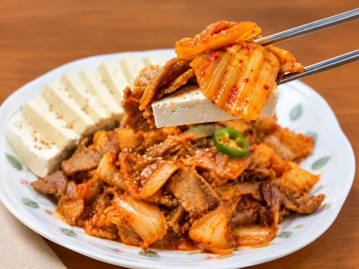 Warm tofu slices served with stir-fried pork and kimchi